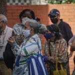 Personas de tercera edad haciendo colas para retirar efectivo en el banco