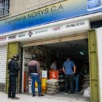 Personas haciendo cola para entrar a una ferreteria por la semana de flexibilización
