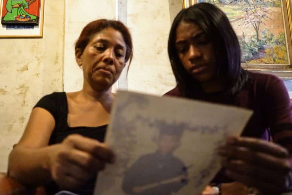 Carmen Arroyo y su sobrina observando una foto de Cristian Charris, asesinado por las FAES