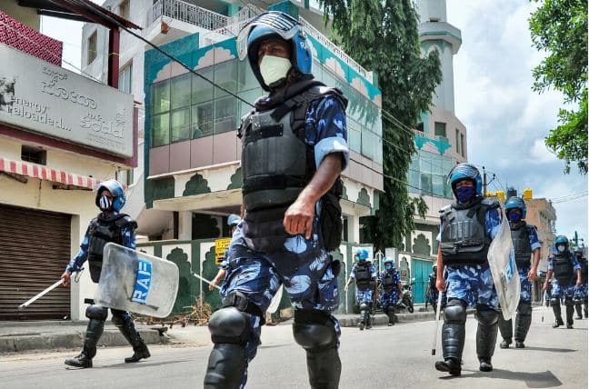 Personal de la Fuerza de Acción Rápida patrullaba una calle en Bangalore, India, en agosto después de que una publicación en Facebook sobre el profeta Mahoma provocó disturbios