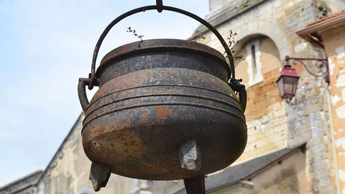 Why are brooms and cauldrons associated with witches?